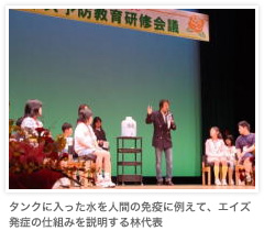 タンクに入った水を人間の免疫に例えて、エイズの発症の仕組みを説明する林代表